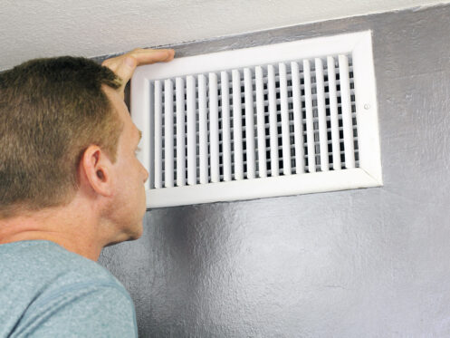 Homeowner looking in vent for source of musty odor